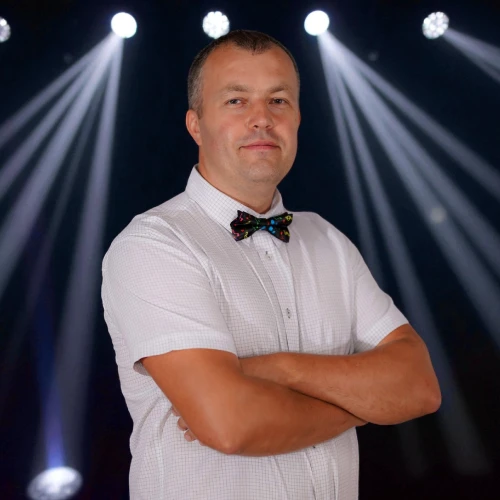 DJ Doman Dariusz Domański podczas pracy na scenie z oświetleniem weselnym