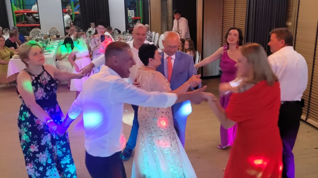 Jubilaci tańczą w środku koła utworzonego przez Gości podczas Rocznicy Ślubu. Radosna atmosfera.